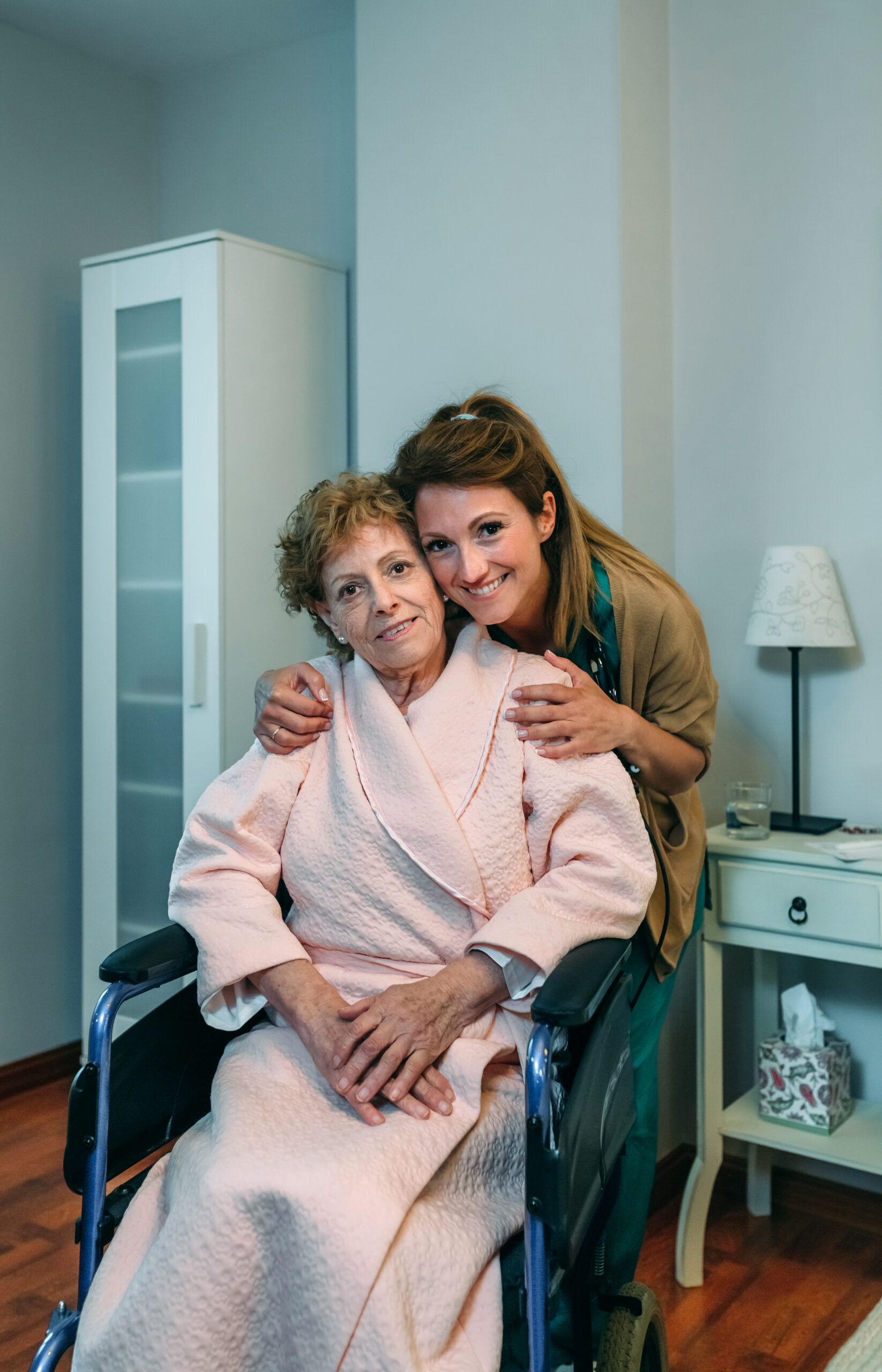 Affectionate caretaker posing with elderly patient Affectionate female caretaker posing with elderly female patient