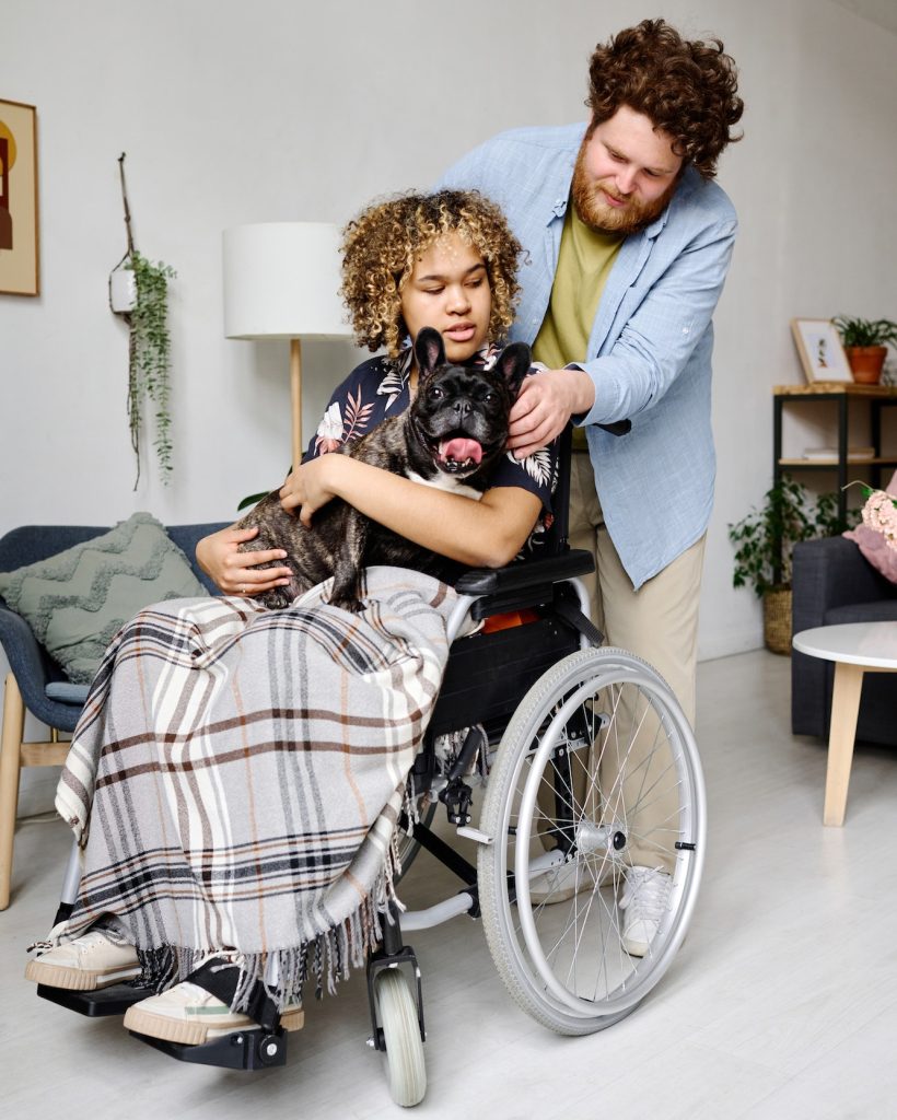 Young man caring about girl with disability at home